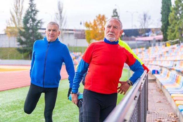 경기장 에서 달리기 전 에 함께 스트레칭 하는 노인 들