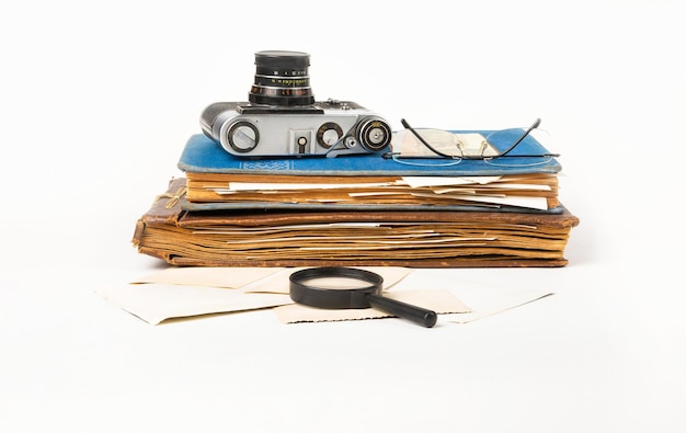 Old photo album with photographs and a camera on a white background