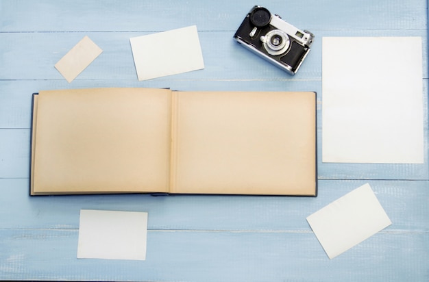 Old photo album with photos on a beautiful wooden table and old camera