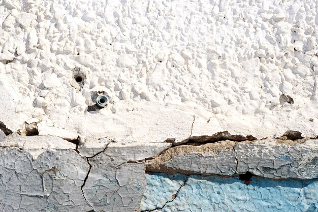 Old plaster wall and peeling paint in blue