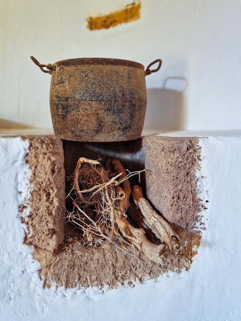 Old pot with roots of ginseng on a white wall.