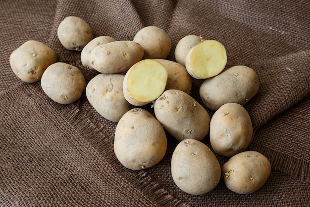 Old potato with young sprouts on a wooden table ready for planting