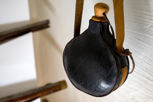 An old powder horn made of black leather a closeup photo
