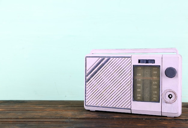 Old radio set on wooden table on blue