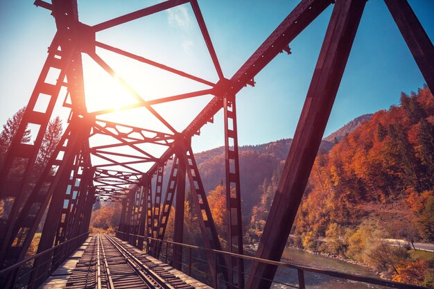 Photo old railway on the bridge over the mountain river in autumn