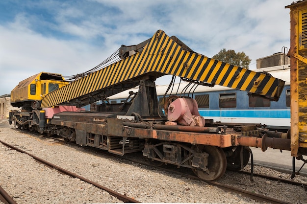 Old railway hoisting crane stands on the rails