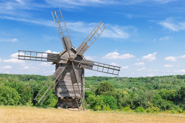 Old Rare Ancient Wooden Windmill in front of Blue Cloud Sky