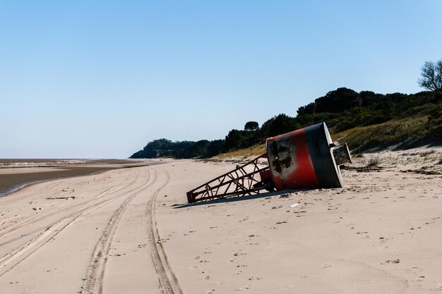 Foto vecchio faro di segnalazione rosso e nero incagliato sulla spiaggia kiyu san jose uruguay