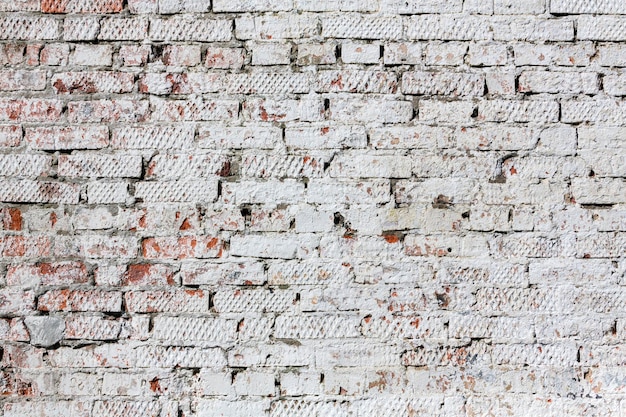 Old red brick wall with peeling plaster