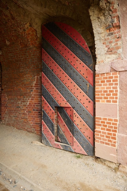 Старые красные ворота в стене замка