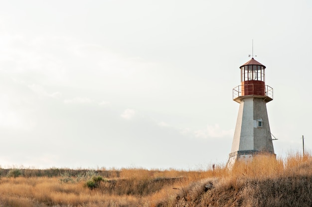 Old red lighthouse on a hill of dry straw