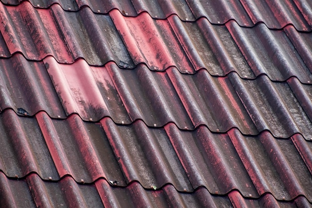 검은 회색 지붕으로 얼룩진 오래 된 빨간 기와 지붕 오래 된 더러운