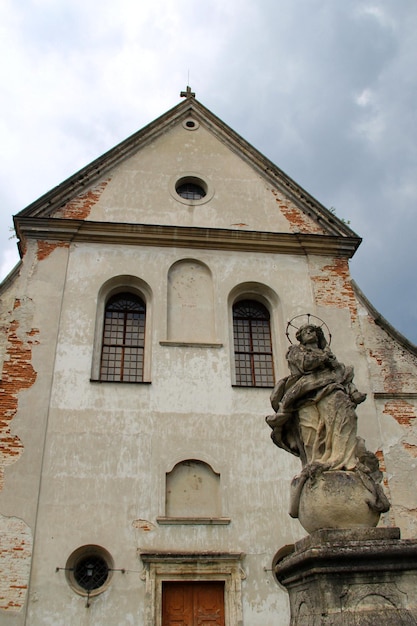 Old Religious Statue In Front Of Abandoned Church