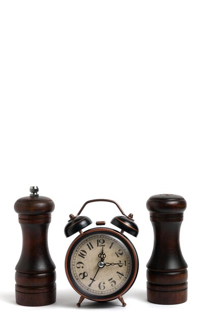 Photo old retro alarm clock and two pepper shakers on white backgroundtime for cooking