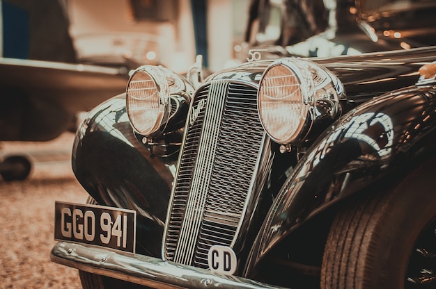 写真 ヘッドライトとグリルの古いレトロな車の正面図。