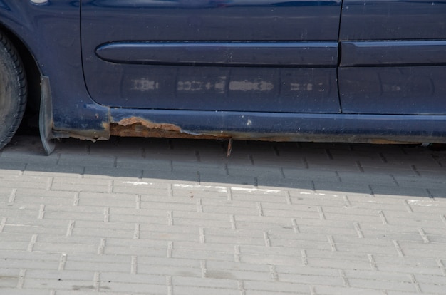 Old, retro car with rust on the metal. side view. rusty body,\
the bottom threshold of the car