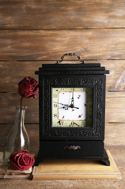 Old retro clock on wooden background