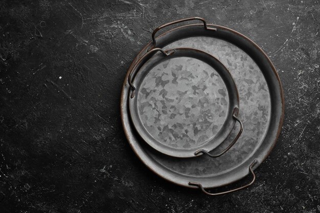 Old retro metal tray on a black stone background Top view Free copy space