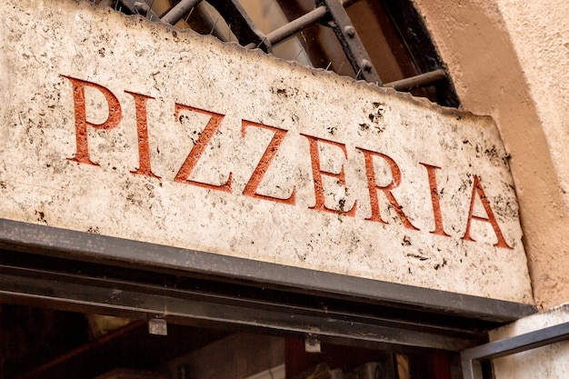 Old retro pizzeria signboard in Rome, Italy.