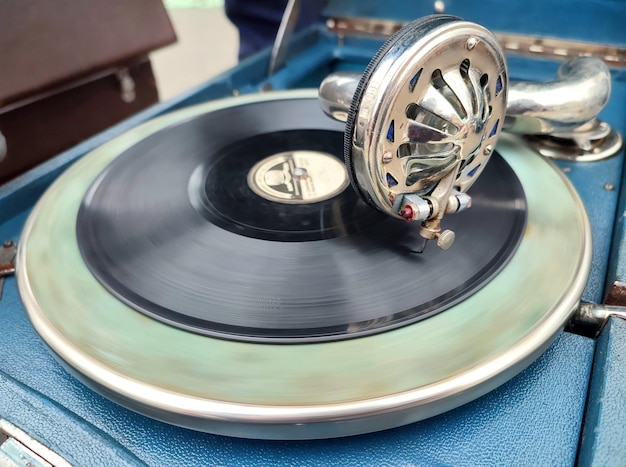 An old retro record playing on old vintage gramophone at flea market work of portable gramophone old