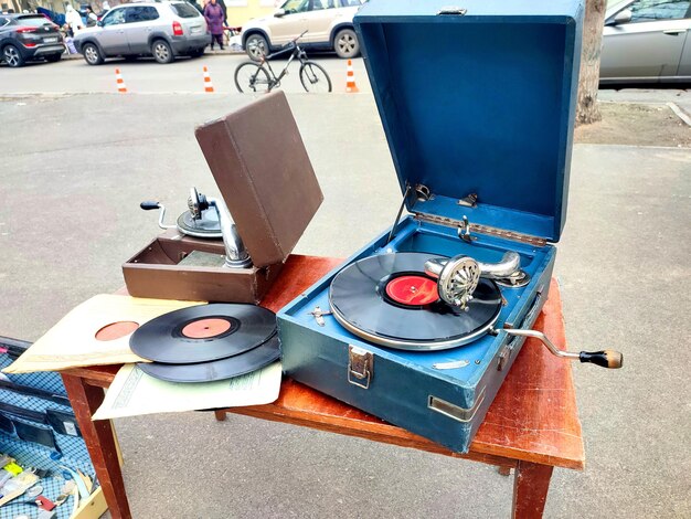 Un vecchio disco retrò suonato su un vecchio grammofono vintage al mercato delle pulci lavoro di un vecchio gramofono portatile