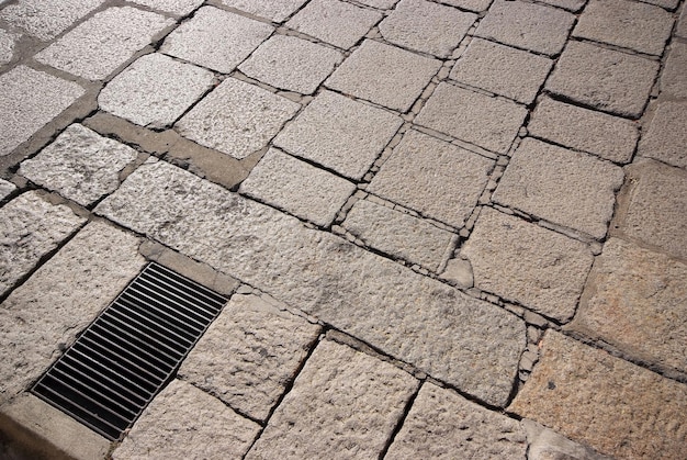 Old road paved with the cobble stones and steel grating