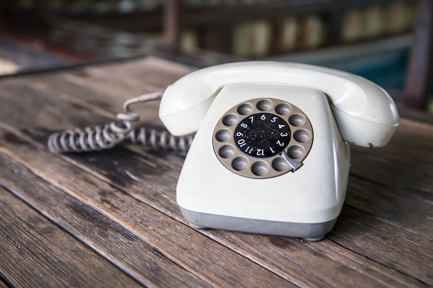 old rotary telephone on wood table