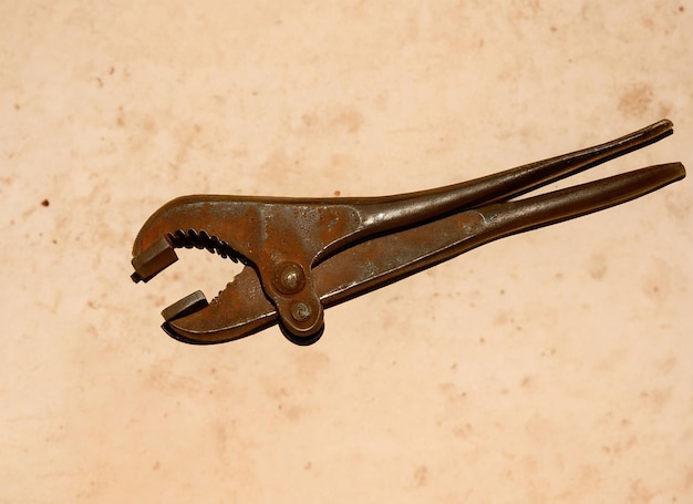 Old round plier tool with brown background
