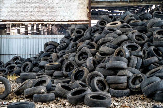 Photo old rubber tires dumped. view of mound of used car tires in a junkyard