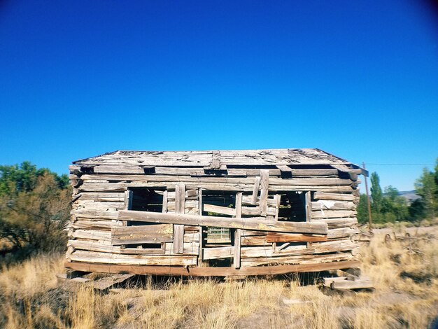 Old ruin on field against clear blue sky