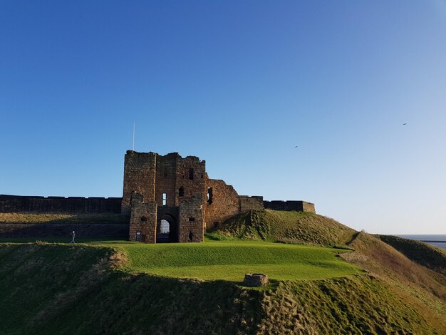 Foto vecchie rovine sul campo contro un cielo blu limpido