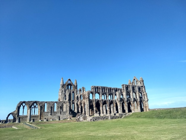 Old ruin on land against blue sky