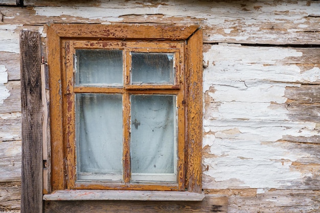 An old ruined wooden house in the village Details of the facade of a historic wooden house with carved shutters and vintage decor elements