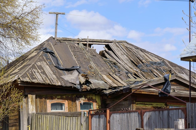 Old rural abandoned wooden collapsing house Old roof destroyed building