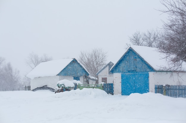 Old rural house. Snow blizzard. A lot of snow