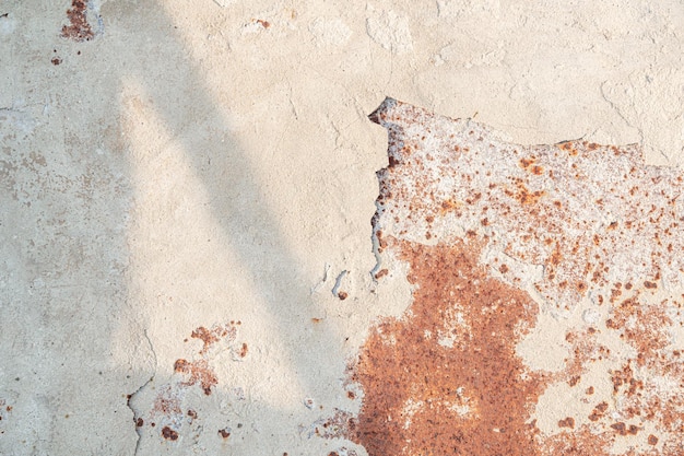 La vecchia superficie arrugginita è parzialmente ricoperta di calce sbriciolata con ombra. sfondo naturale.