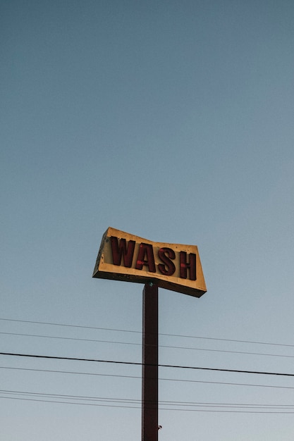 Old rustic car wash sign in the blue sky