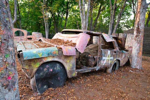 Foto una vecchia automobile arrugginita e abbandonata in una base di paintball