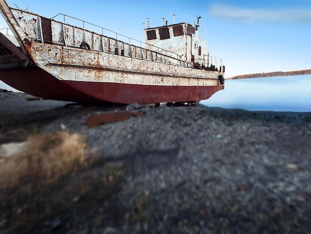 Foto vecchia nave arrugginita abbandonata in rovina una nave abbandonata arrugginita su una spiaggia rocciosa