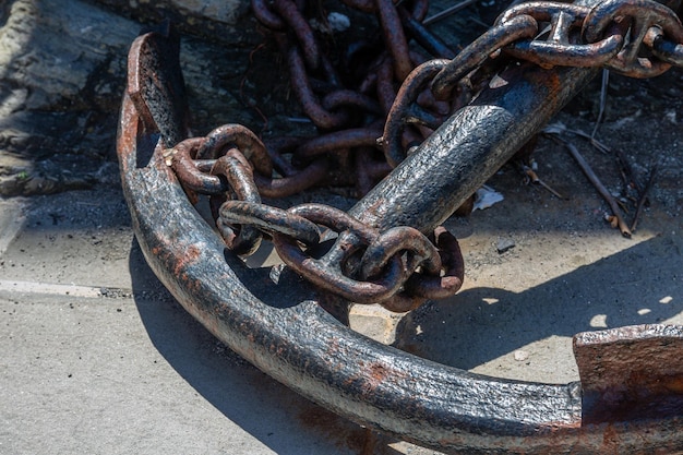 Old rusty anchor with chain on sunny day