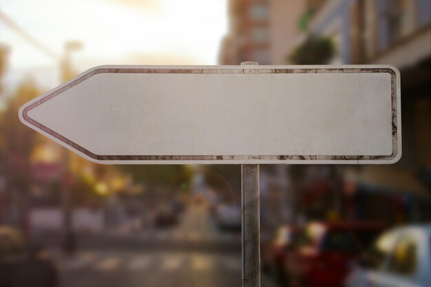 Old rusty blank sign board with arrow to left stand in city\
while sundown is a mock up