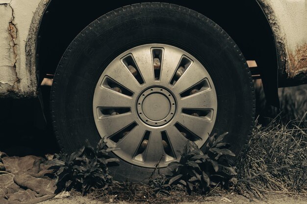 Old rusty car wheel. Cracked tires and rusted hubcaps.