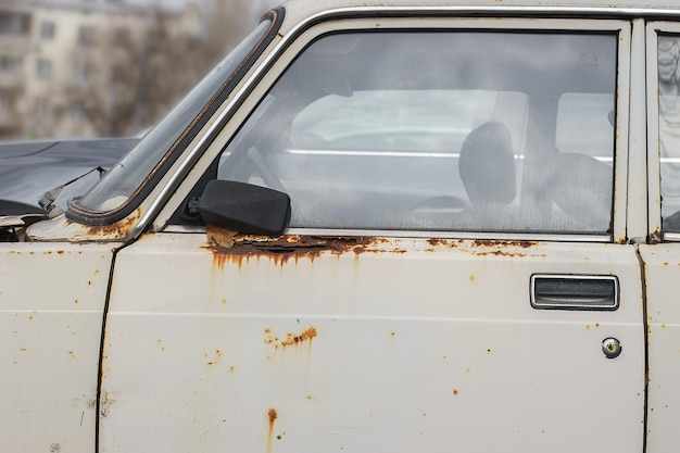 Old rusty and dusty car parked in the street