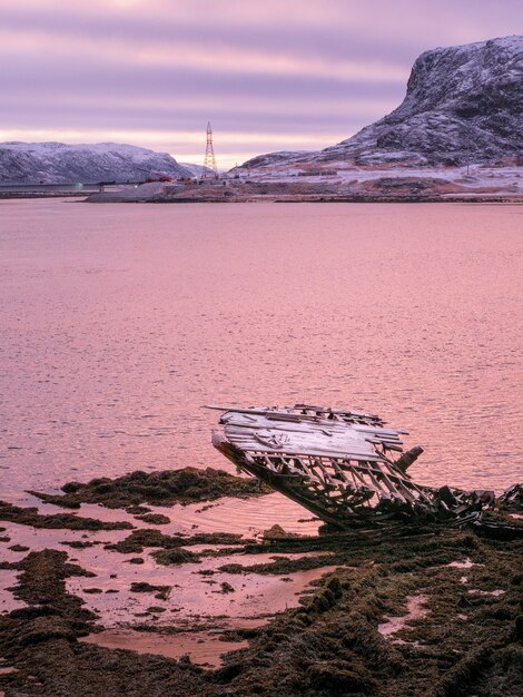 An old rusty fishing boat abandoned by a storm on the shore