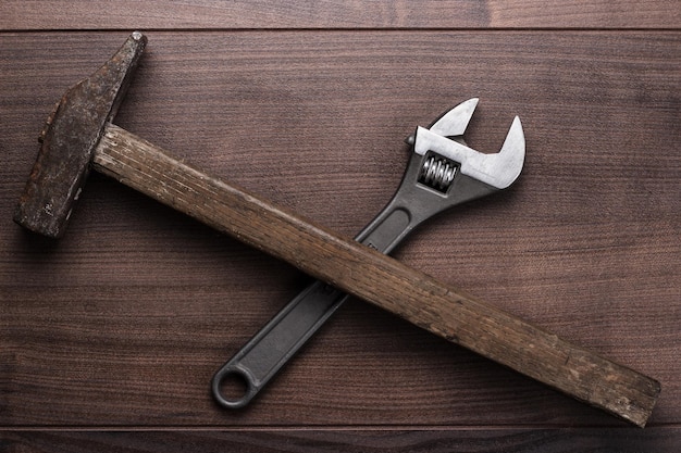 Old rusty hammer and wrench on the table