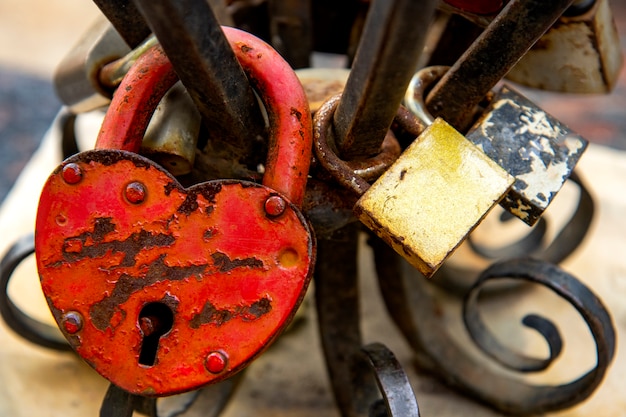 Old rusty heart shaped locks on a wrought iron railing 