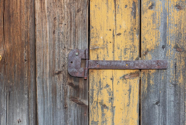 An old rusty hinge on an old wooden dilapidated door