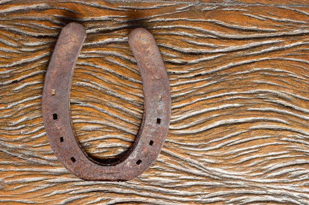 Old and rusty horseshoe on rustic wooden table