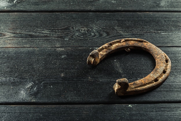 Old rusty horseshoes on wooden board