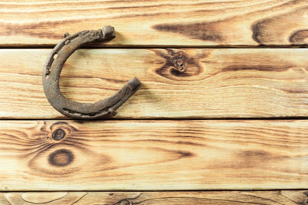 Foto vecchi ferri di cavallo arrugginiti sul bordo di legno